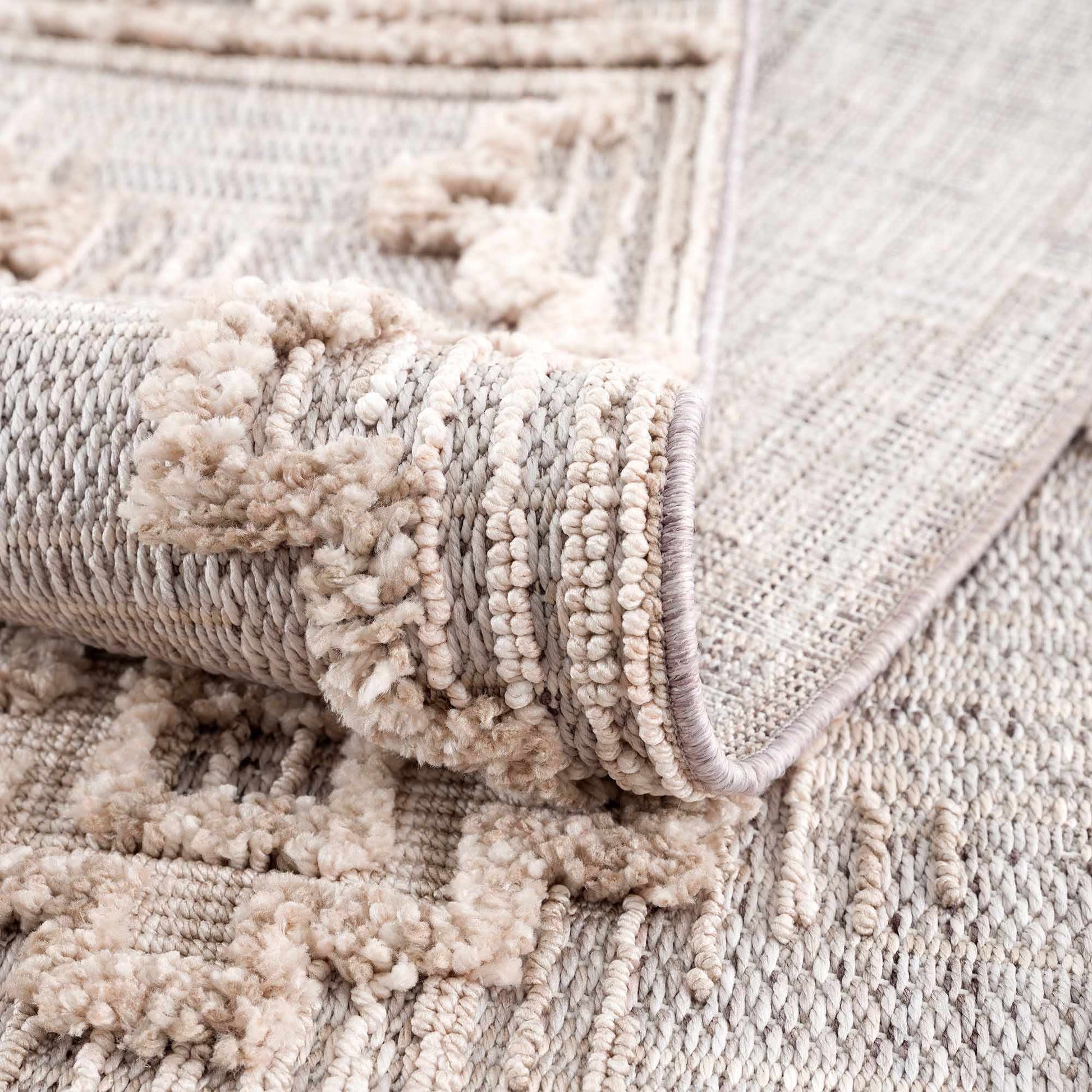 Close-up of a textured beige rug with a clear plastic sheet on top