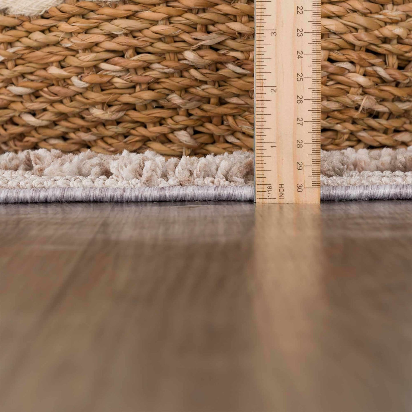 Close-up of a woven mat with a ruler showing measurements on a wooden floor.