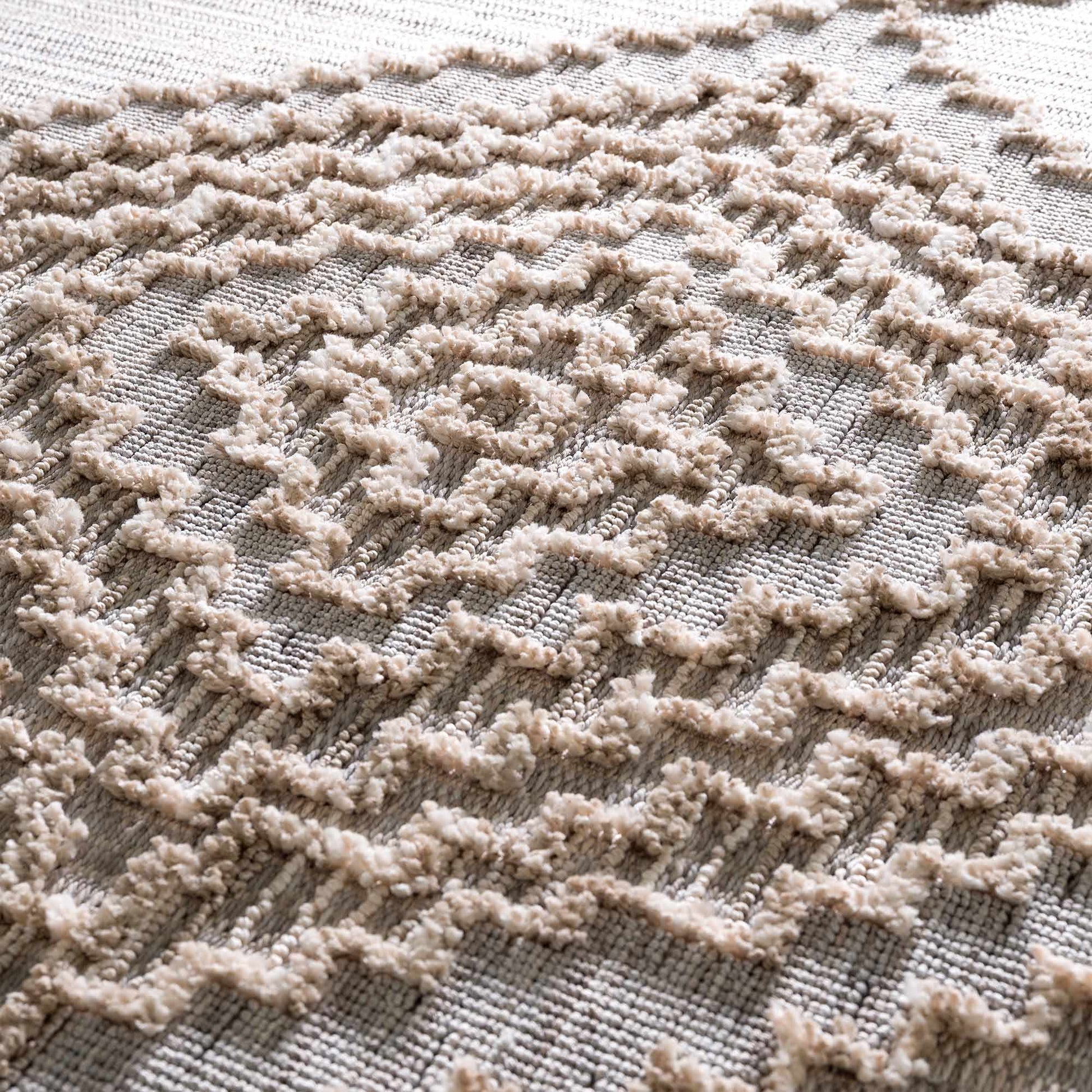 Close-up of a textured beige rug with a geometric pattern