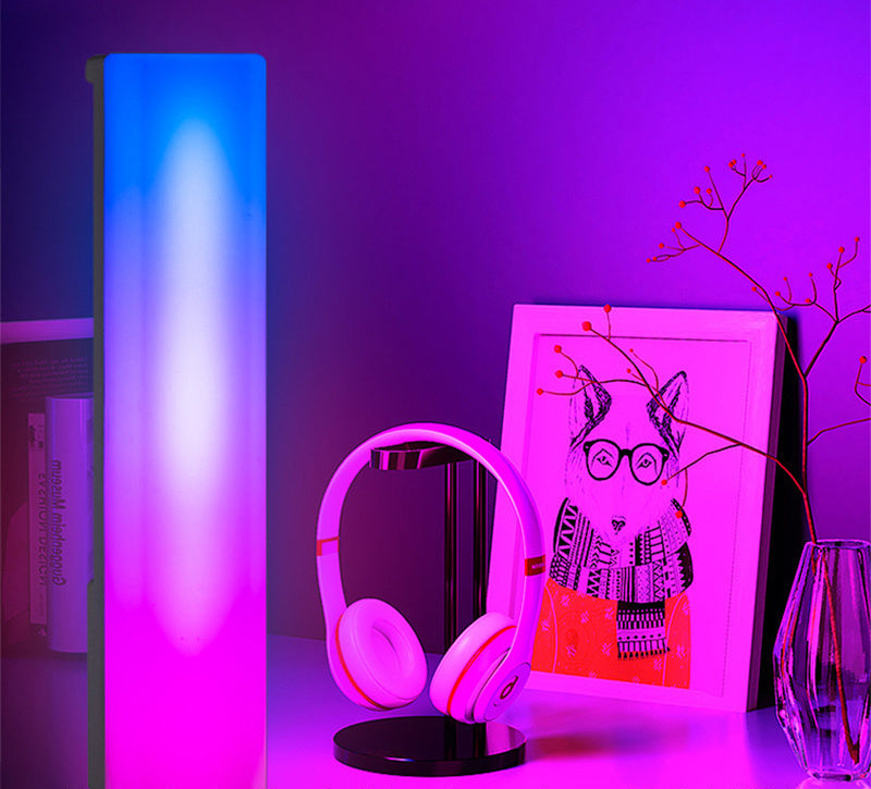 Pink headphones on a stand with a purple light and decorative items in the background