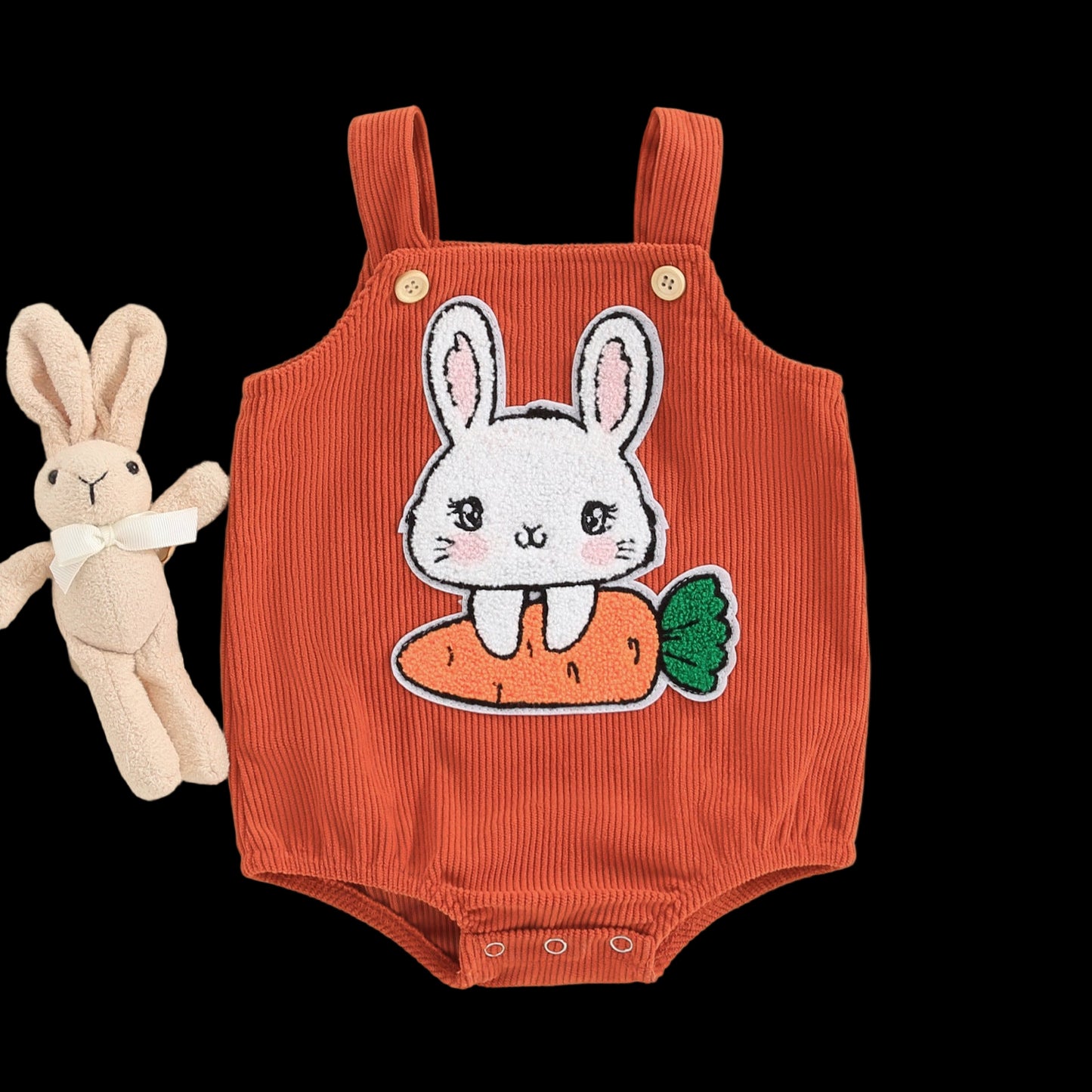 Orange baby romper with bunny and carrot design on a beige background