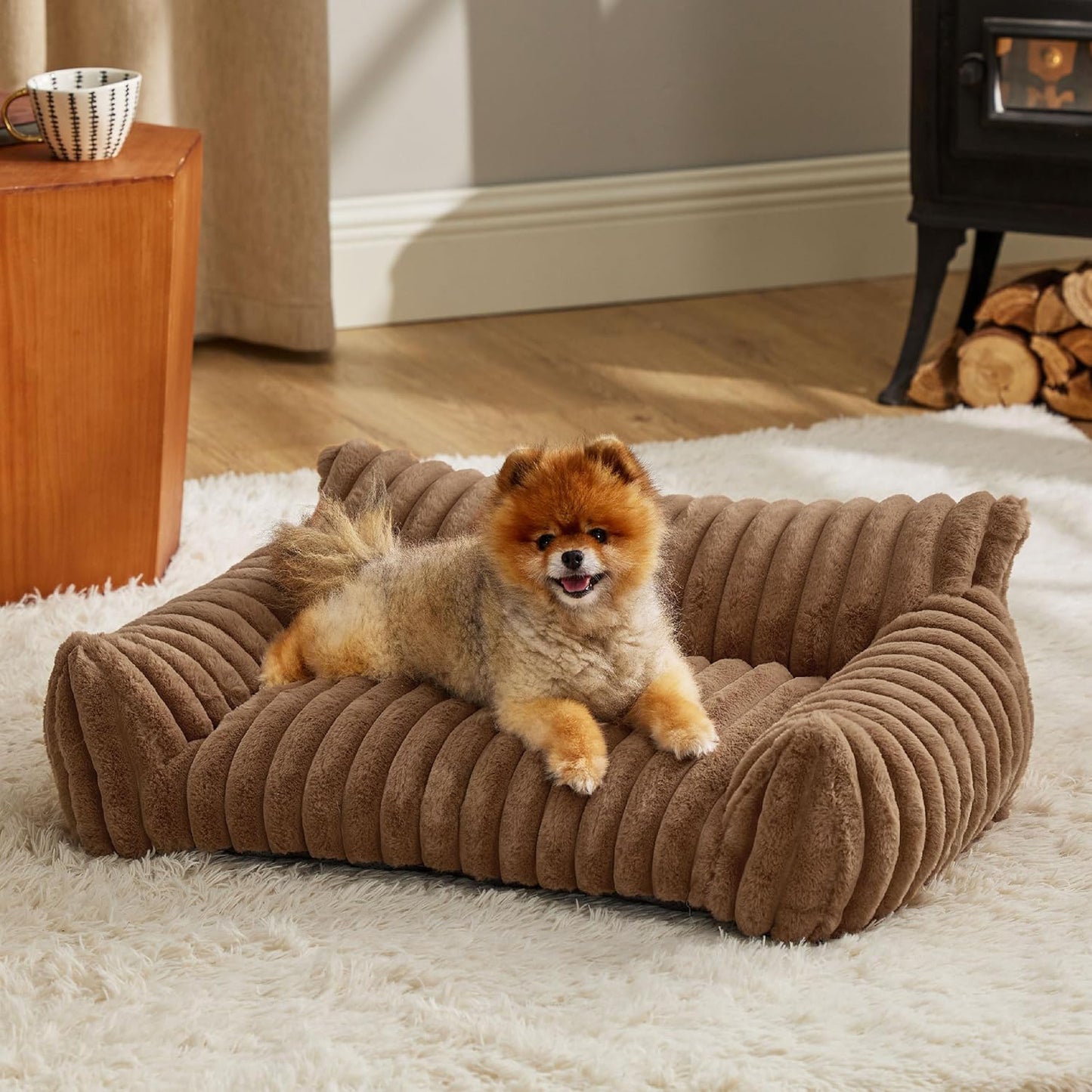 Small dog lying on a brown ribbed pet bed in a cozy living room.