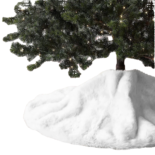 White fur tree skirt on a wooden floor with a decorated Christmas tree in the background.