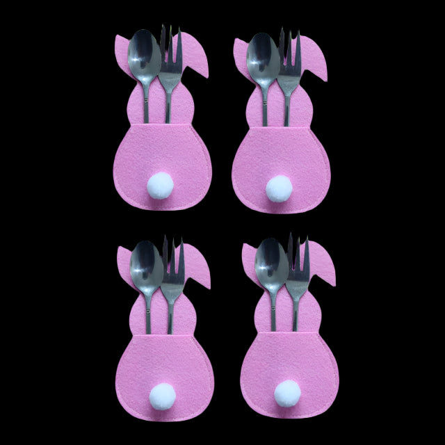 Four pink bunny-shaped cutlery holders with silver spoons and forks on a white background