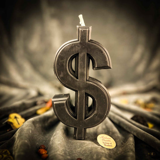 Candle shaped like a dollar sign on a dark fabric background