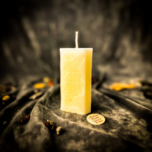 White candle on a dark fabric background with a blurred effect
