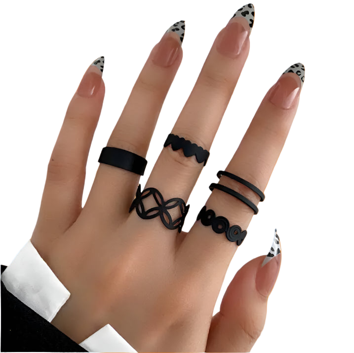 Hand wearing multiple black rings with a plain background