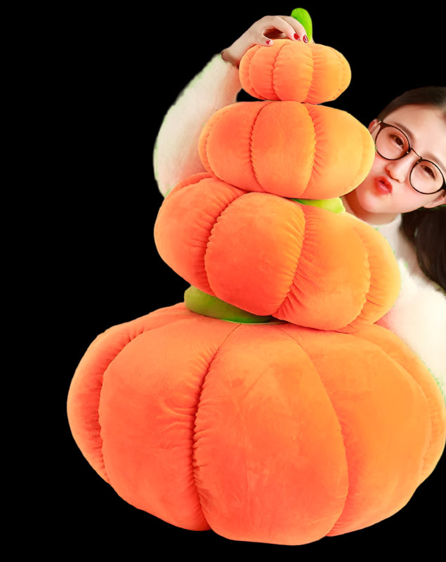 Stack of orange plush pumpkins held by a person on a checkered floor.