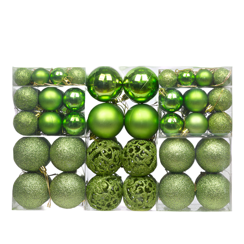Assorted green Christmas ornaments in a clear box on a white background
