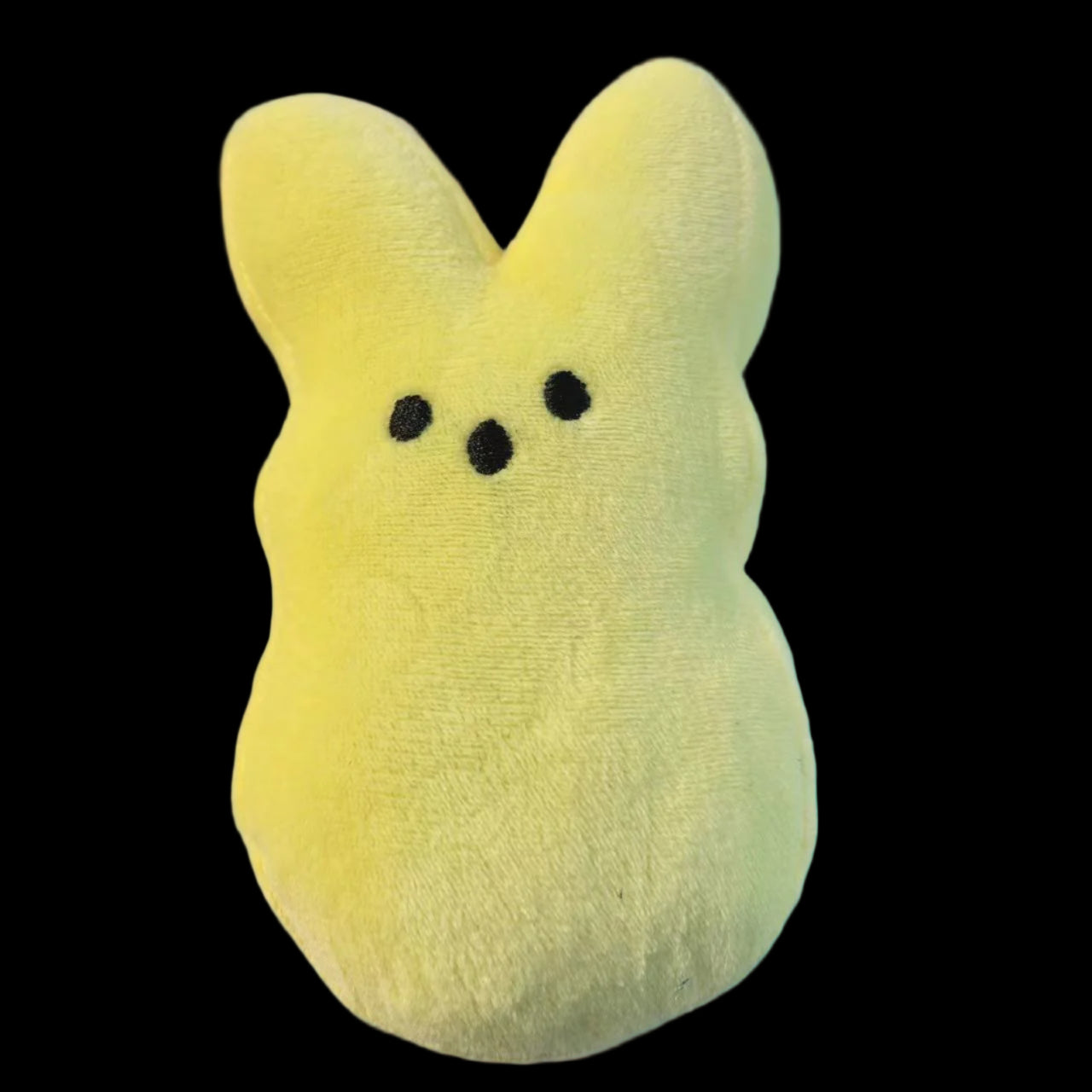Yellow plush toy with a simple face on a gray background