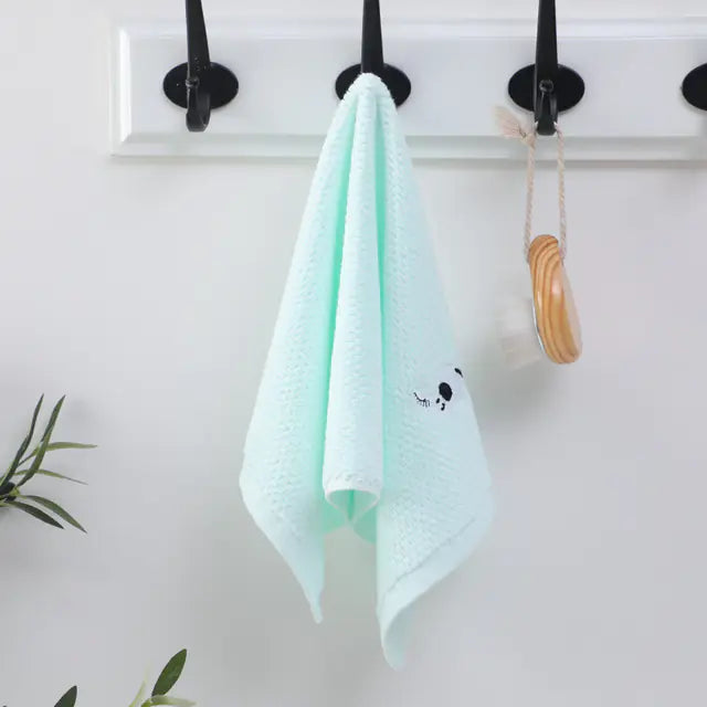 Light blue towel hanging on a hook with a white background