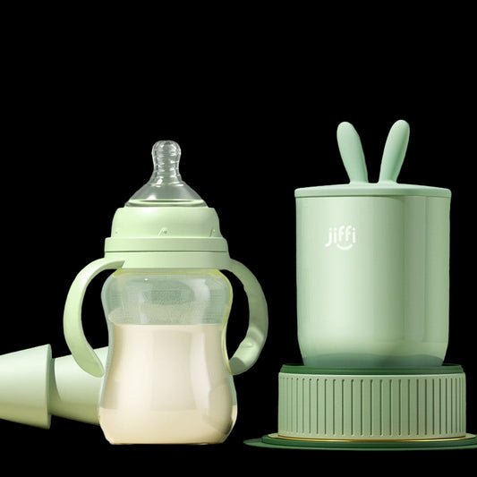 Green baby bottle and cup set on a light green background