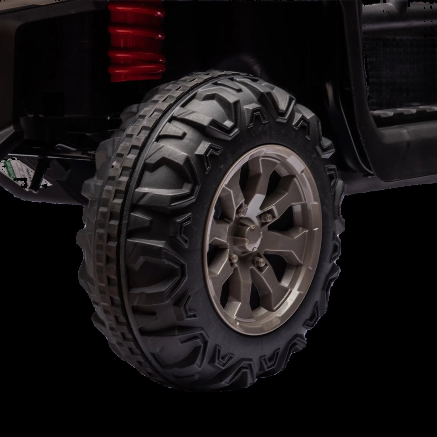 Close-up of a black off-road tire with tread pattern on a white background