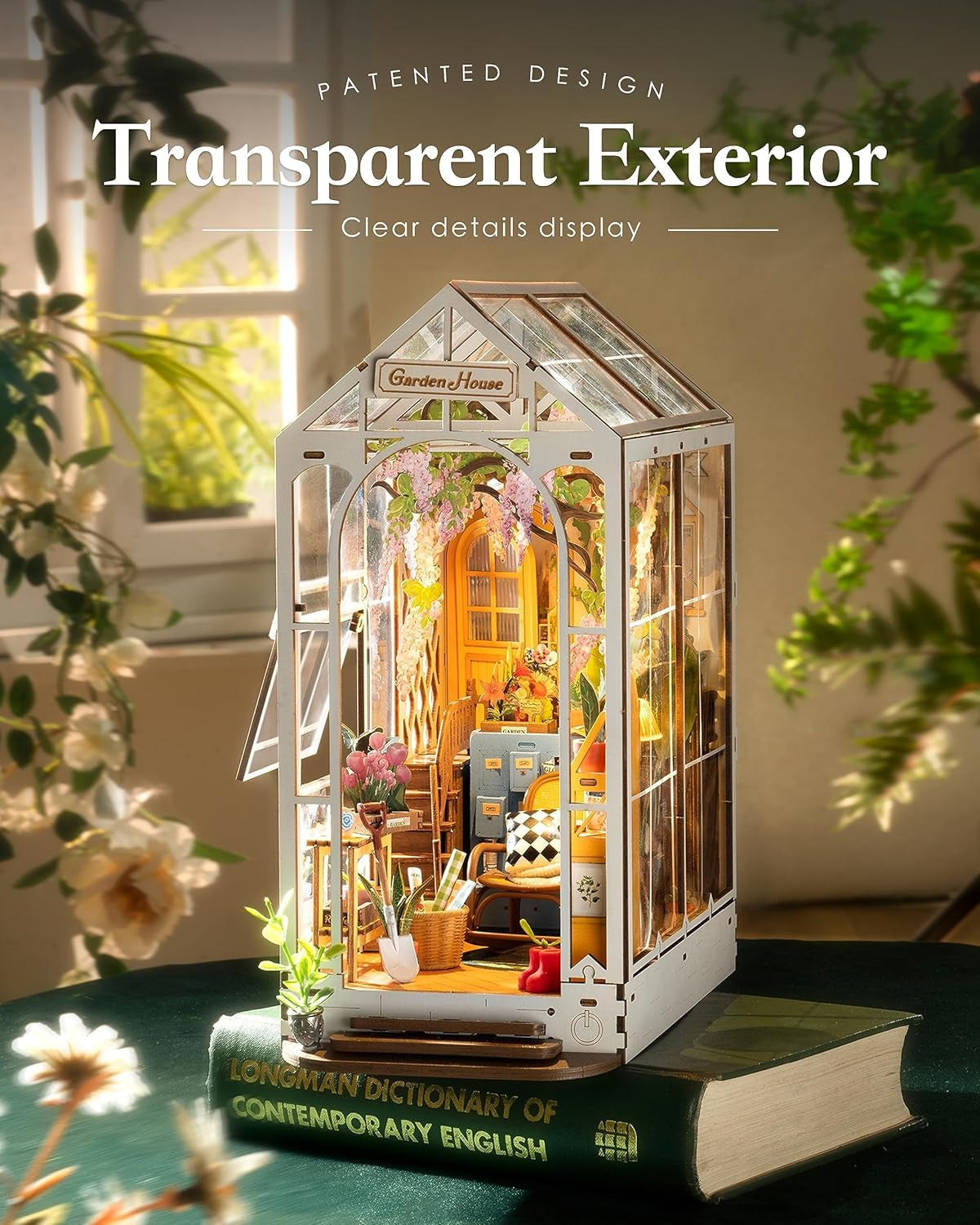 Transparent exterior display case with interior details, placed on a book with plants in the background.