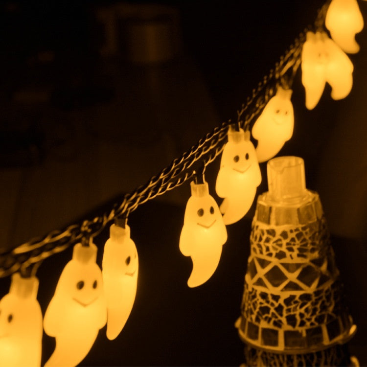 String of ghost-shaped lights with a decorative lantern on a dark background