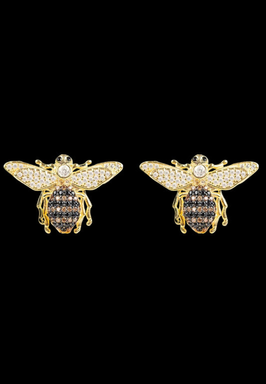 Gold bee-shaped earrings with black gemstones on a white background