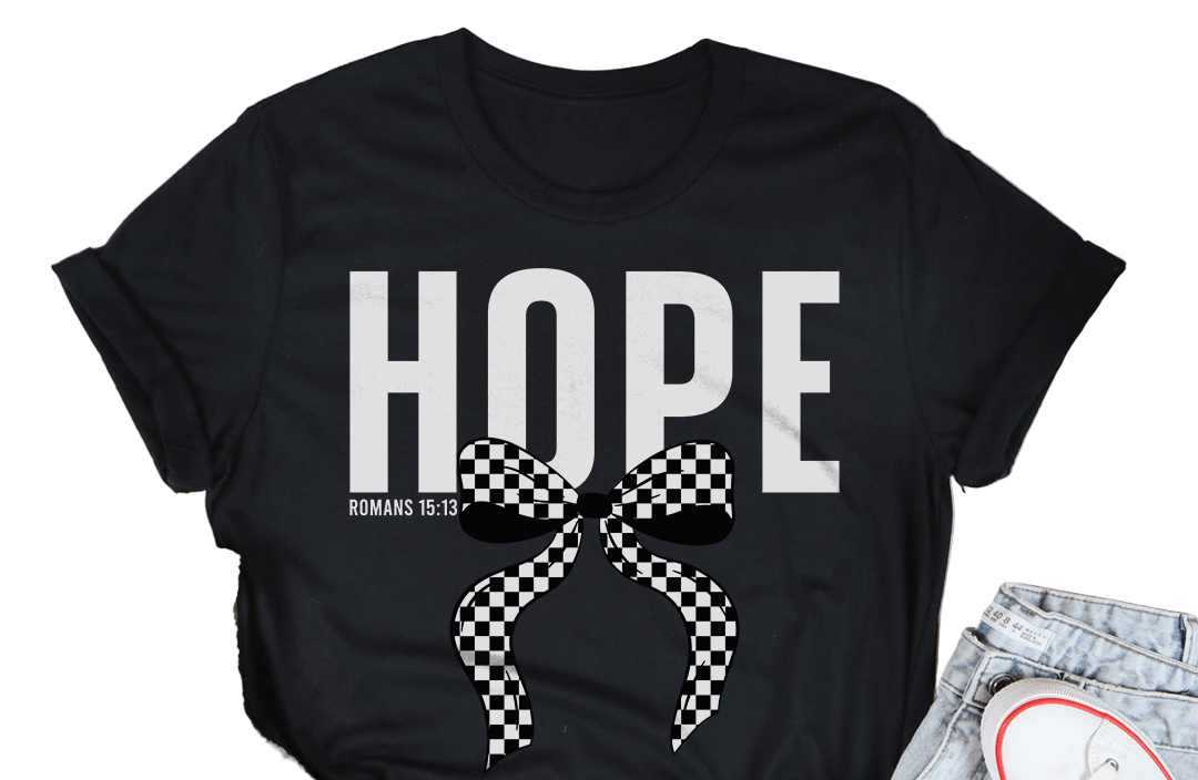 Black t-shirt with 'HOPE' and a bow graphic on a wooden surface with casual items.
