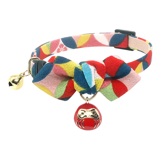 Colorful braided dog collar with a red bell and gold charm on a white background