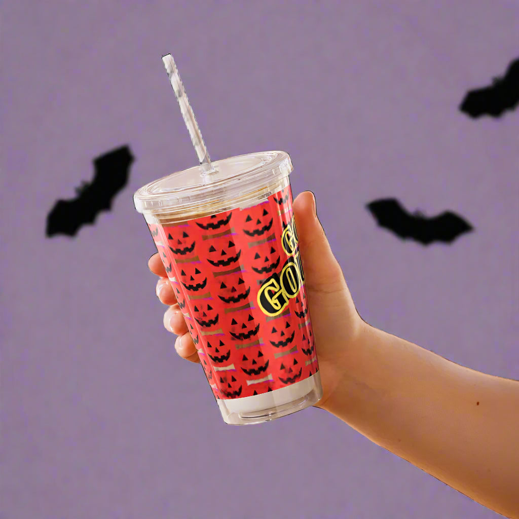 Hand holding a red tumbler with black jack-o'-lantern pattern and 'Ghouls' text.