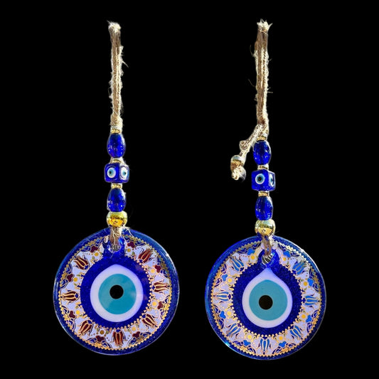 Pair of blue evil eye earrings with gold accents on a light gray background