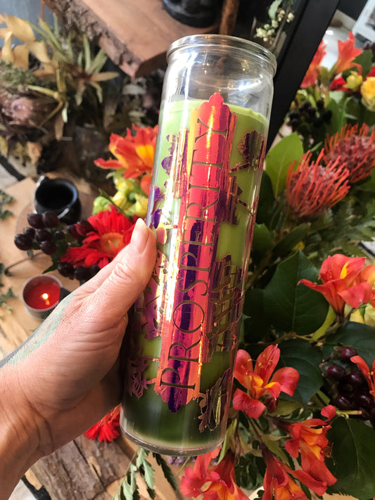 Hand holding a colorful candle with floral decorations in the background