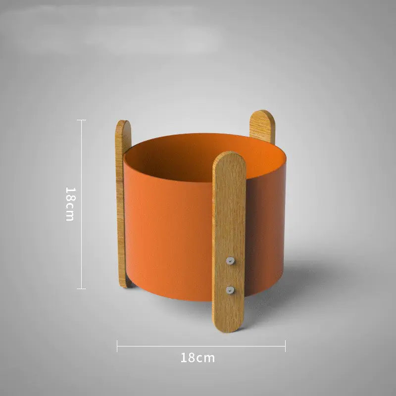 Orange cylindrical container with wooden handles on a gray background