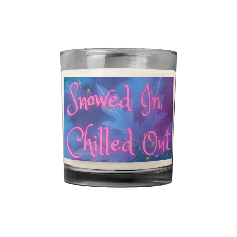 Candle with a colorful label reading 'Snowed In Chilled Out' on a white background