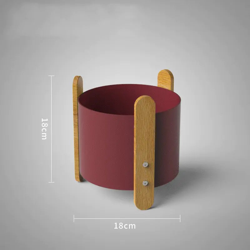 Red cylindrical container with wooden handles on a gray background