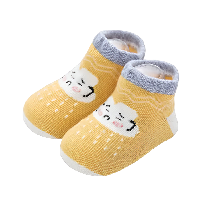 Yellow baby socks with cartoon faces on a white surface