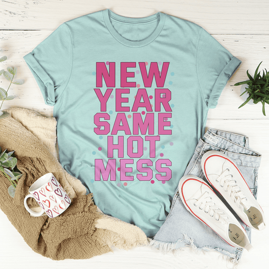 Light blue t-shirt with pink text 'NEW YEAR SAME HOT MESS' on a white surface with casual items.
