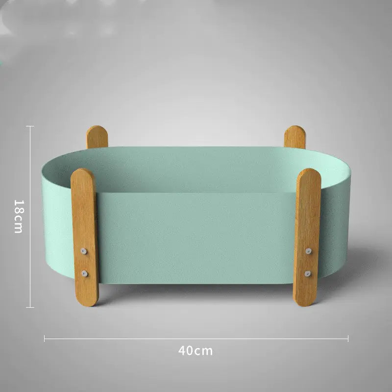 Green pet bed with wooden sides and dimensions on a gray background