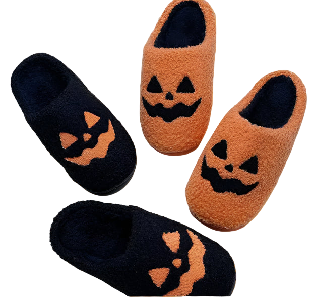 Pair of black and orange slippers with jack-o'-lantern designs on a white textured background.