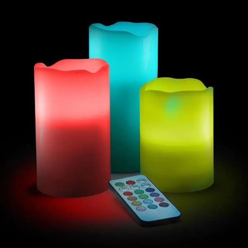Three colorful LED candles with a remote control on a dark background