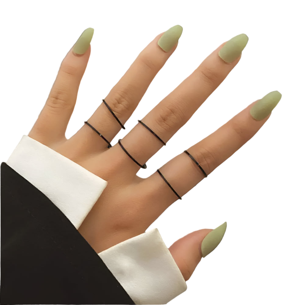 Hand with green nails and black rings on a neutral background