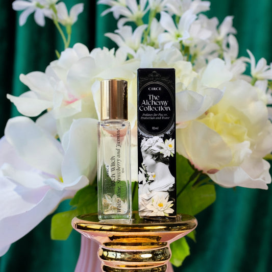 Perfume bottle and packaging with flowers on a glittery pink background