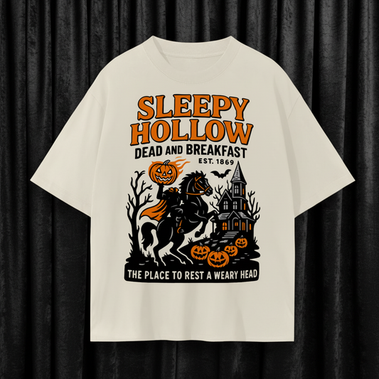 Beige t-shirt with 'Sleepy Hollow Dead and Breakfast' graphic design on a white background