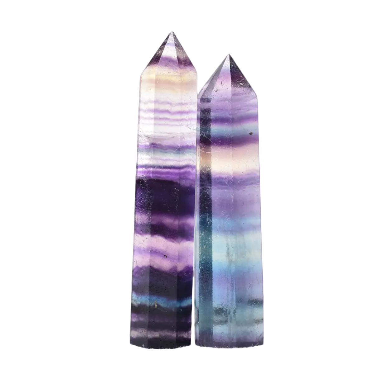 Two multicolored crystal towers on a white surface with a blurred background