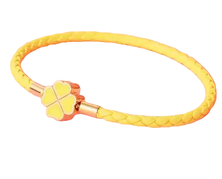 Yellow braided bracelet with a clover charm on a pink background