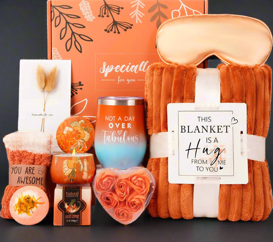 Gift set with blanket, candles, and other items in an orange box.