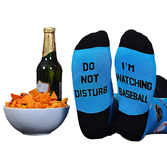 Two socks with humorous text on a table with snacks and a bottle.