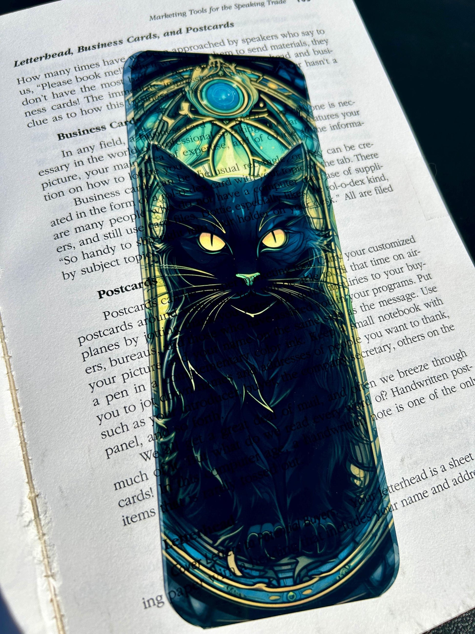 Phone case with a black cat design on an open book