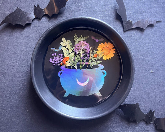 Decorative plate with a colorful Cauldron of Flowers design on a dark background with bat decorations.