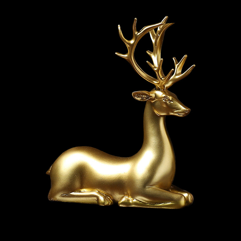 Gold deer figurine on a reflective surface with a dark background