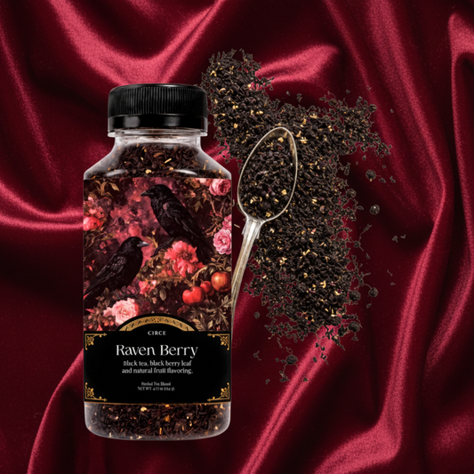 A bottle of Cuck Rack Raven Berry herbal tea with a black cap, shown next to a metal spoon filled with loose dried black berries and tea leaves on a white background.