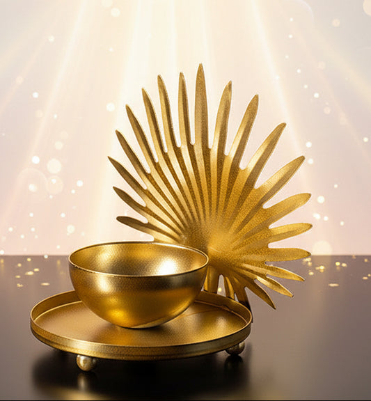 Gold decorative bowl and leaf-like structure on a black background