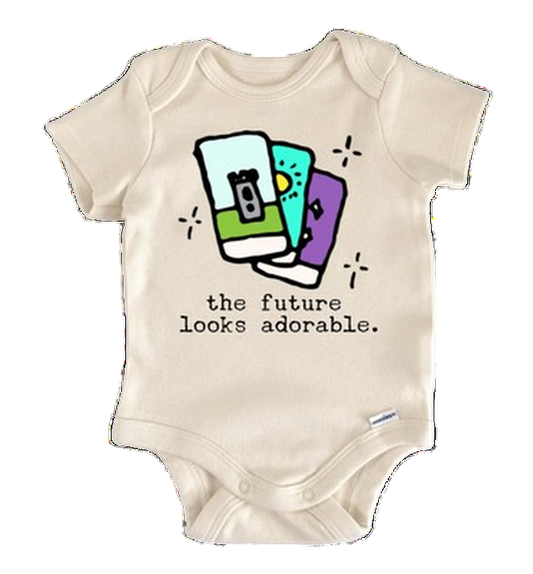 Beige baby onesie with colorful graphic and text 'the future looks adorable' on a white background