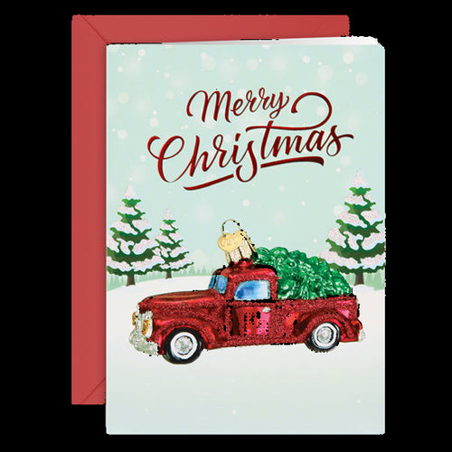 Christmas card with a red truck carrying a Christmas tree and 'Merry Christmas' text.