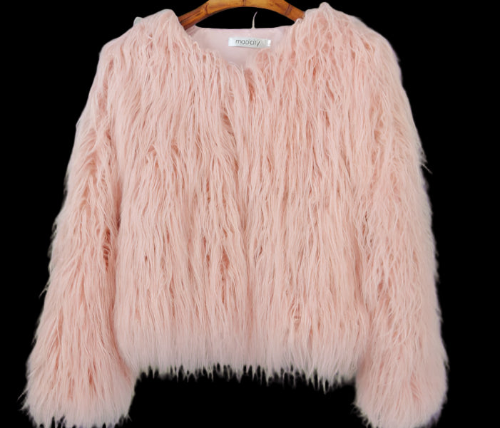 Pink fluffy sweater on a hanger against a gray background
