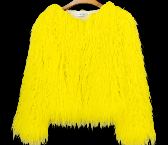 Yellow fluffy sweater on a hanger against a gray background
