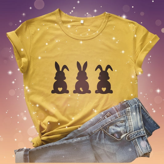 Yellow t-shirt with black rabbit illustrations on a wooden surface with jeans and berries.